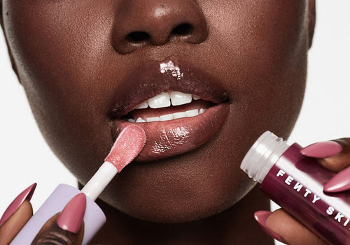 Model applying Fenty Treatz Lip Oil in Black Cherry. Model applying Fenty Treatz Lip Oil in Black Cherry.