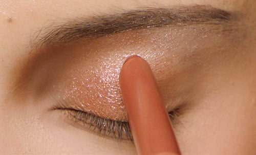 Macro shot of model applying Shadowstix Diamonds Diamond Veil Eyeshadow Stick to eyelid.