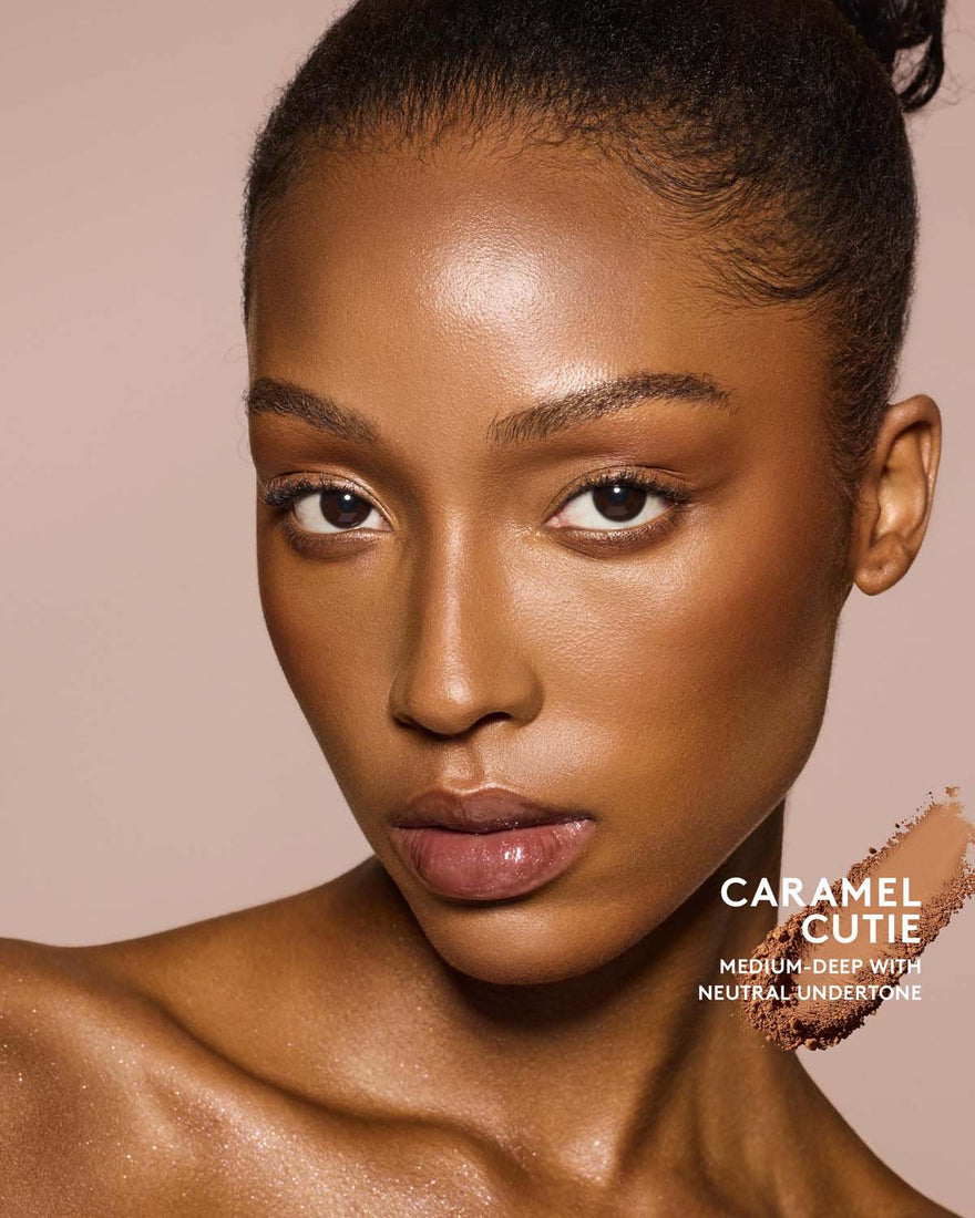 Medium- deep skin tone model wearing sun stalk'r bronzer in shade Carmel Cutie.
