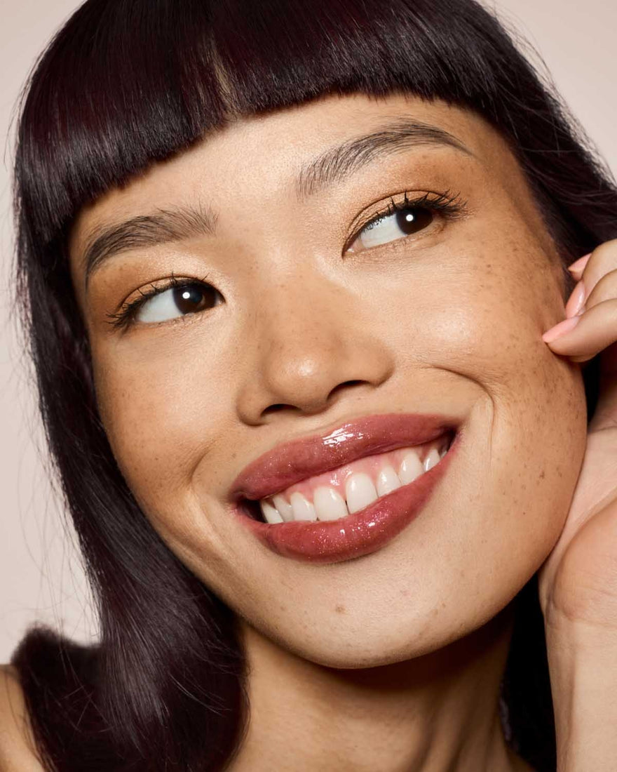 light skin toned model wearing gloss bomb universal lip luminizer in shade Hot Chocolit