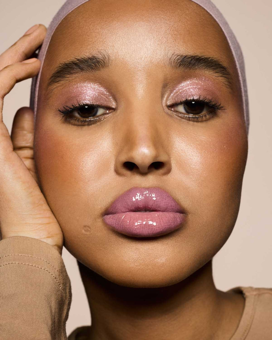 medium skin toned model wearing gloss bomb cream in shade mauve wives