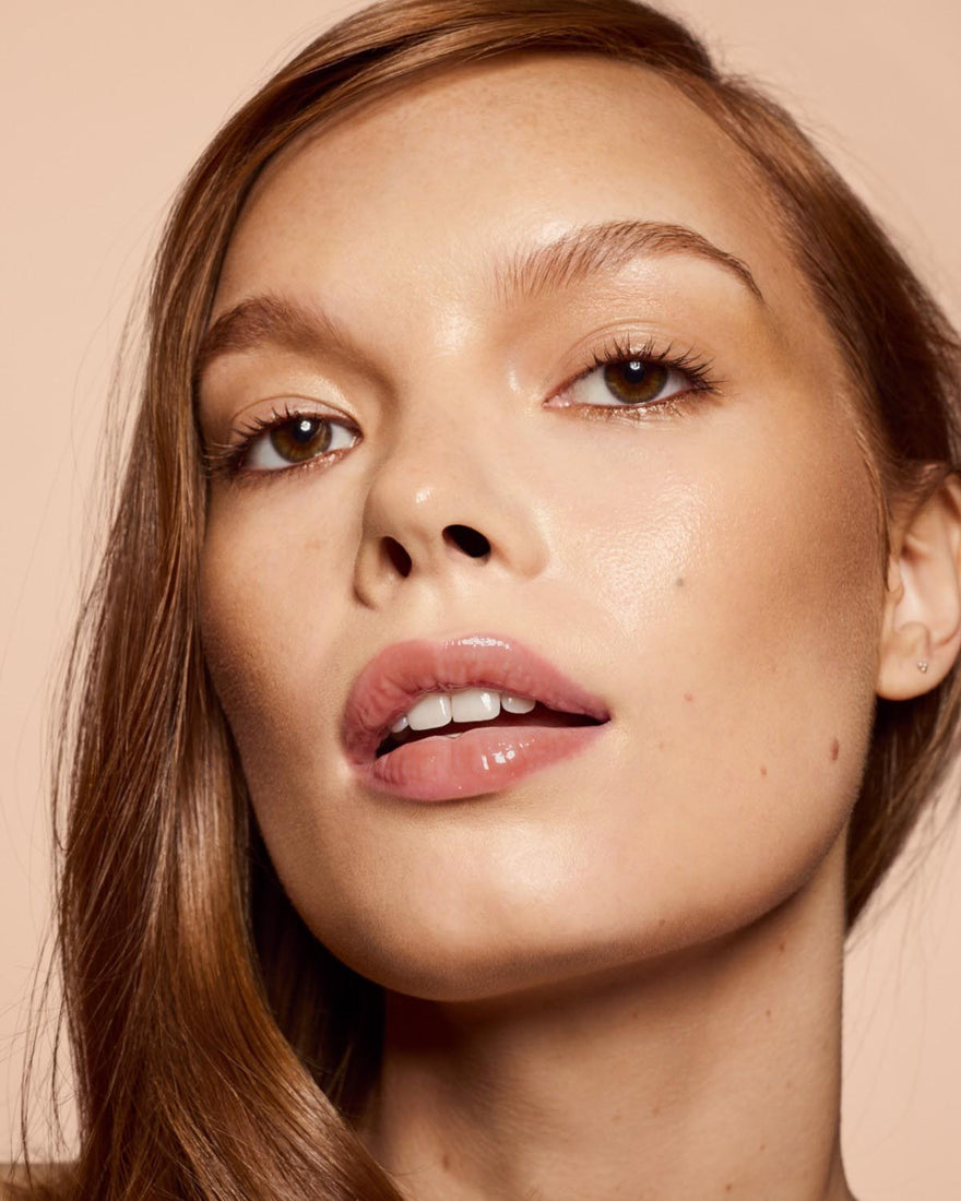 light skin tone model wearing Gloss Bomb Heat Universal Lip Luminizer + Plumper in shade Fenty Glow Heat